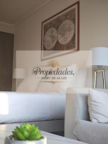 a living room with a couch and a sign on the wall at Suits vistas al mar con balcón pisos altos in Antofagasta