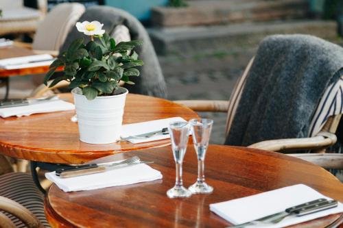 a wooden table with two glasses and a potted plant on it at Garner Hotel Elmshorn by IHG in Elmshorn