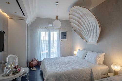 a bedroom with a white bed and a table and a window at Irida Parga in Parga
