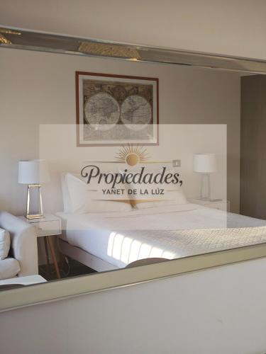 a bedroom with a bed with a sign on it at Suits vistas al mar con balcón pisos altos in Antofagasta