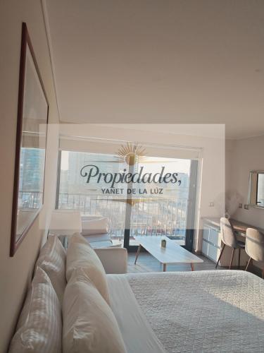 a bedroom with a bed and a view of a building at Suits vistas al mar con balcón pisos altos in Antofagasta
