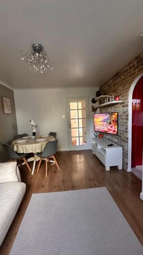 a living room with a couch and a table and a tv at Cozy Apartment in London