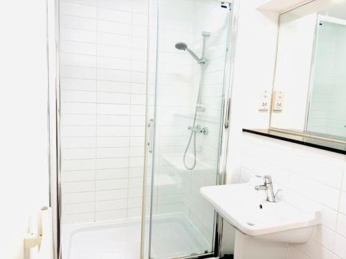 カンタベリーにあるLovely Studio at Canterbury City Centreのシャワーと洗面台を備えた白いバスルーム