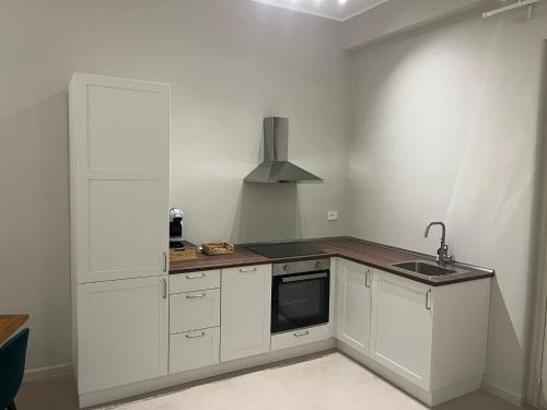 a kitchen with white cabinets and a sink at Dimore del Borgo in Catania