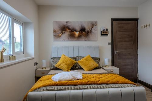 a bedroom with a large bed with yellow pillows at Luxehaus MCR in Manchester