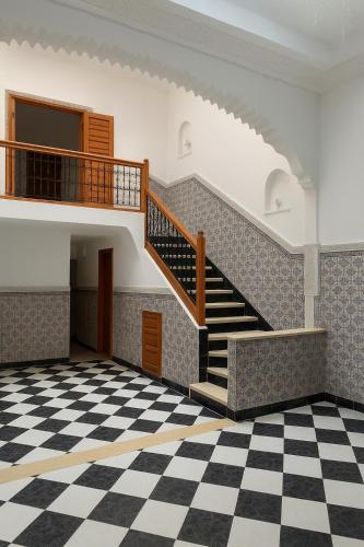 ein leeres Zimmer mit einer Treppe und einem karierten Boden in der Unterkunft Riad Nahara in Marrakesch