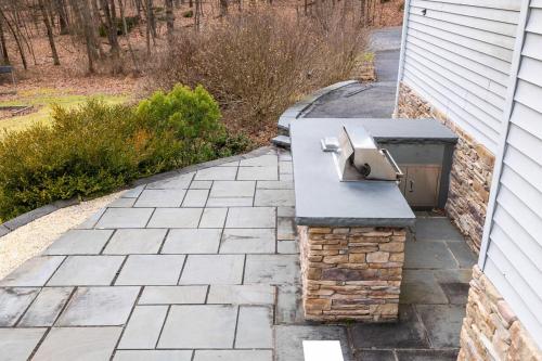 a bird feeder on a brick patio next to a house at Very Private Large Home on 22 Acres in Chester