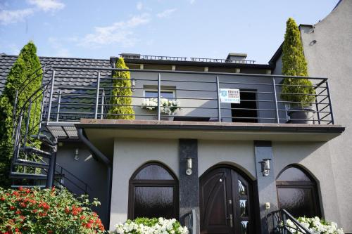 a house with a balcony on top of it at POKOJE GOŚCINNE IRGA in Starogard Gdański