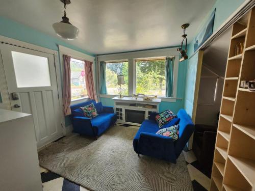 a living room with two blue chairs and a desk at Lakeview Suite by Trout Lake in Vancouver