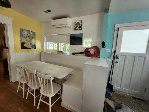 a kitchen with a table and chairs and a guitar on the wall at Lakeview Suite by Trout Lake in Vancouver