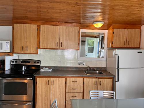 a kitchen with wooden cabinets and a white refrigerator at Camping Chalets Lac St-Augustin in Quebec City