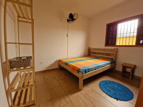 a bedroom with a bed and a ladder and a window at A Ver o Mar Guest House in Caraguatatuba