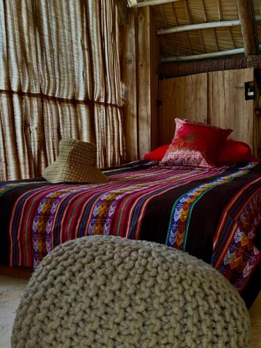 a bedroom with two beds and a ottoman at Ganesh Hostel in El Valle
