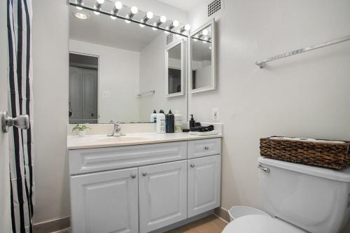 a bathroom with a sink and a toilet and a mirror at Stylish 2BR Arlington Near DC Free Parking & Gym in Arlington