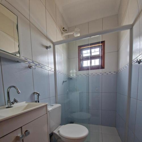 a bathroom with a toilet and a sink and a shower at A Ver o Mar Guest House in Caraguatatuba