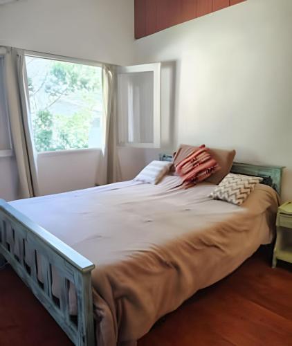 a large bed in a bedroom with a window at Mi Casa Tu Casa D , apto mascotas in Lago Puelo