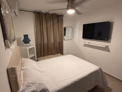 a bedroom with a bed and a flat screen tv at Mi casa es tu casa in El Cachón