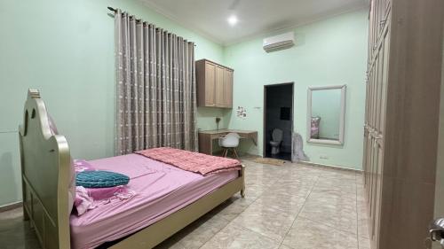 a bedroom with a bed and a desk in it at Hannan Homestay Tangkak in Tangkak