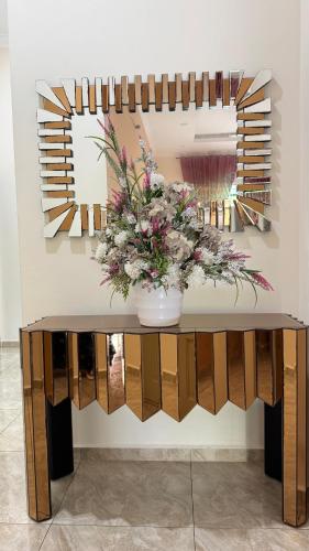 a table with a vase of flowers on a wall at Hannan Homestay Tangkak in Tangkak