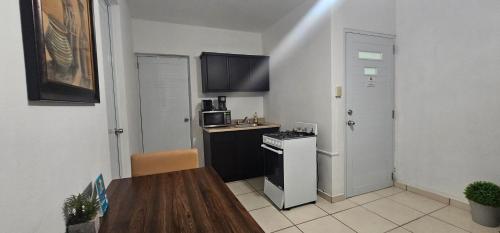 a small kitchen with a table and a stove at Discovery Beach Apartments in Aguada
