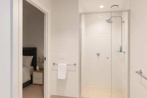 a bathroom with a shower with a glass door at Valentine Sweet Monlando 3 queens private spa pool gym sauna and parking Sleeps 6 in Melbourne