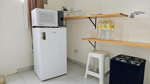 a kitchen with a microwave on top of a refrigerator at Suite 1 - Centro de Convenções700m, AC, WIFI in Recife