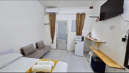 a small living room with a couch and a tv at Suite 1 - Centro de Convenções700m, AC, WIFI in Recife