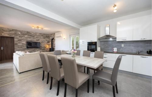a kitchen and dining room with a table and chairs at Cozy Home In Kastel Stafilic in Kaštela