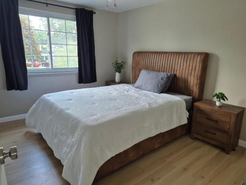 a bedroom with a large bed and a window at Four Bedroom Family and friends cozy home in Sterling Heights