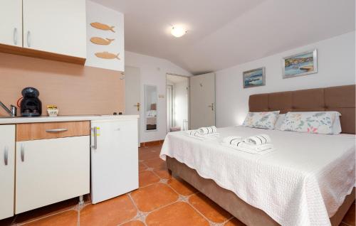 a bedroom with a large bed and a kitchen at Gorgeous Apartment In Karlobag With Wifi in Karlobag
