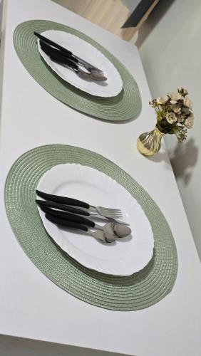 a white plate with a fork and knife on a table at Flats Joice in Petrolina