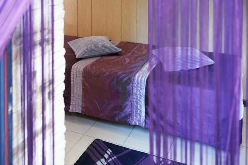 a bedroom with a bed with a purple comforter at Lawendowe Studio in Starogard Gdański