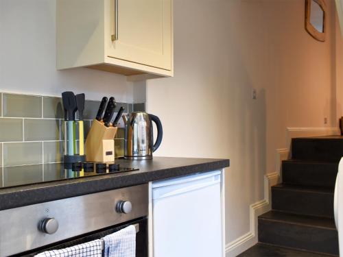a kitchen with a counter top and some knives at The Burrow in Haverthwaite