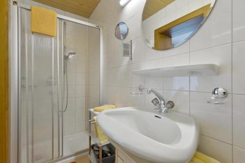 Gästehaus Ahornblick في مايرهوفن: حمام أبيض مع حوض ودش