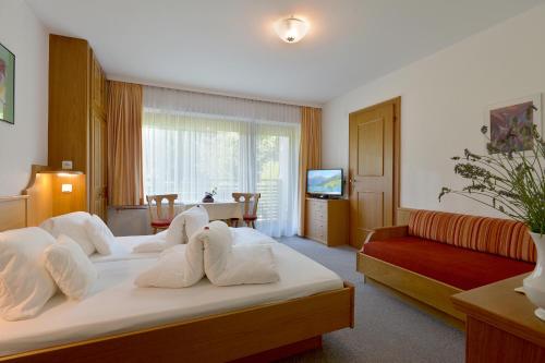 ein Hotelzimmer mit einem Bett und einem Sofa in der Unterkunft Gästehaus Ahornblick in Mayrhofen