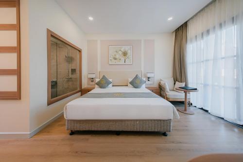 a bedroom with a large bed and a large window at Villa Oasis in Luang Prabang