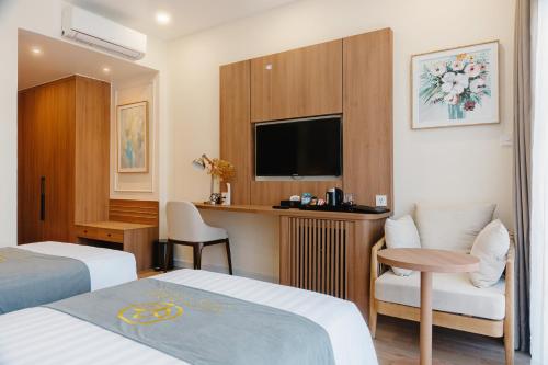 a hotel room with two beds and a flat screen tv at Villa Oasis in Luang Prabang
