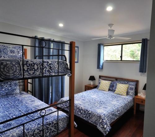 ein Schlafzimmer mit zwei Etagenbetten und einem Fenster in der Unterkunft Beachcomber - Rainbow Shores in Rainbow Beach