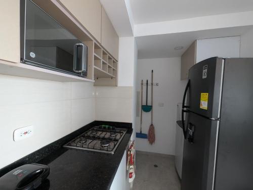 a small kitchen with a refrigerator and a stove at Apartamento amoblado en Cartagena cerca a la playa in Cartagena de Indias