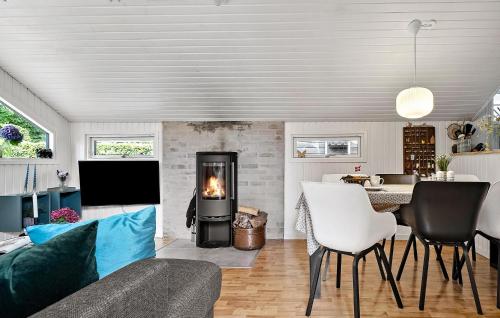 Una sala de estar con chimenea y una mesa. en 3 Bedroom Awesome Home In Bjert, en Binderup Strand