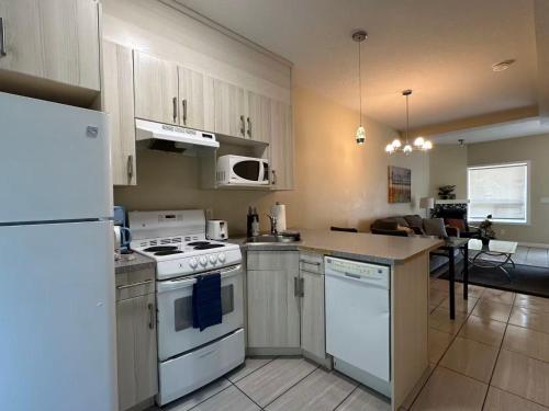 a kitchen with a white stove and a refrigerator at banff woods lodge in Canmore