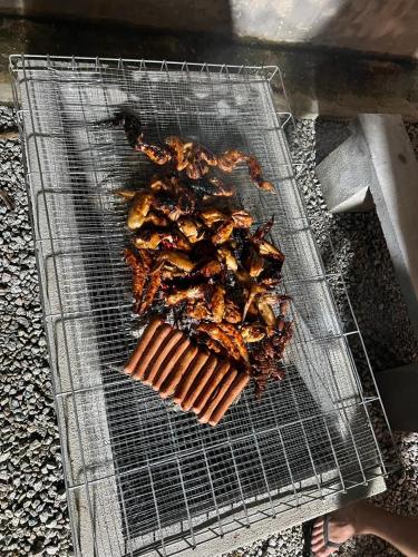 a grill with some food on top at There's A Borneo Guesthouse in Johor Bahru