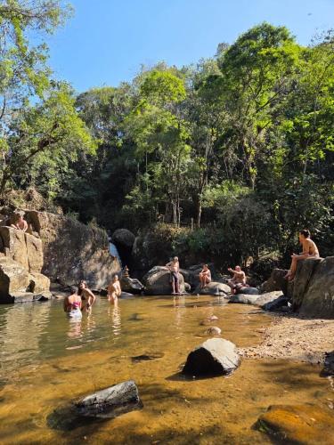a group of people swimming in a river at Quinta São Xico Cabin - São Francisco Xavier in São Francisco Xavier