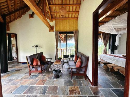 a bedroom with a bed and two chairs and a table at Pu Luong Jungle Lodge in Pu Luong
