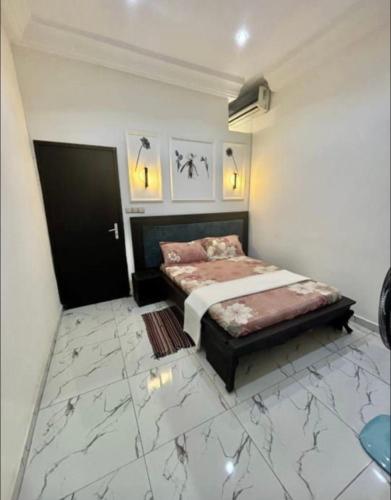a bedroom with a bed in a room with marble floors at Bisola Residences in Cotonou