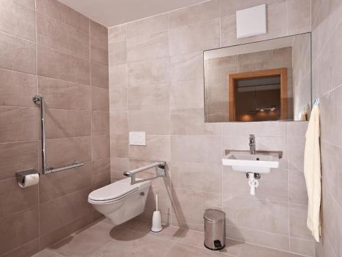 a bathroom with a toilet and a sink at Hotel Neuwirt in Finkenberg