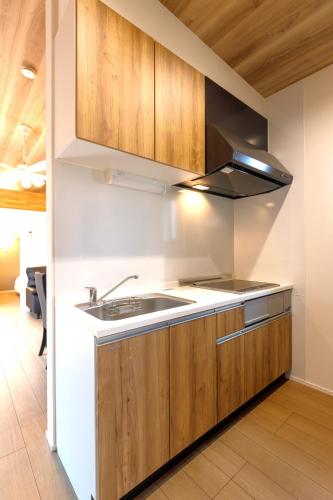 a kitchen with wooden cabinets and a sink at Trailer Ship Garden Aso - Vacation STAY 96758v in Aso