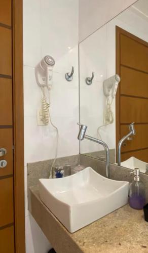 a white sink in a bathroom with a mirror at STOP Mar Suite Privada - NI in Nova Iguaçu