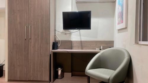 a room with a desk with a chair and a television at STOP Mar Suite Privada - NI in Nova Iguaçu