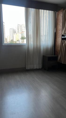 an empty room with a large window with a view at STOP Mar Suite Privada - NI in Nova Iguaçu